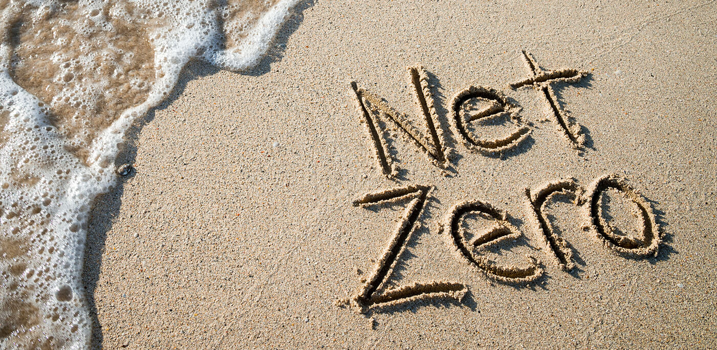 Net zero written in sand