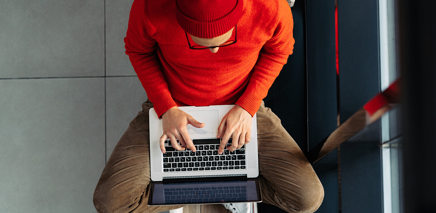Man using laptop dressed in red