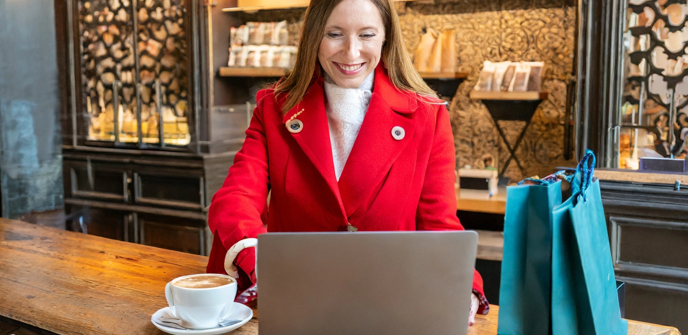 Women on laptop buying clothes whilst in a coffee shop