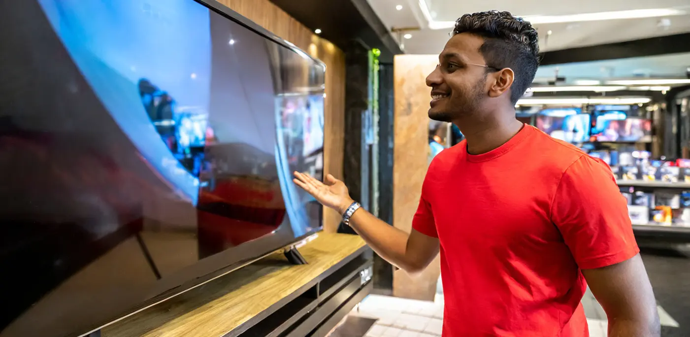 Young man looking at flat screen TVs to buy
