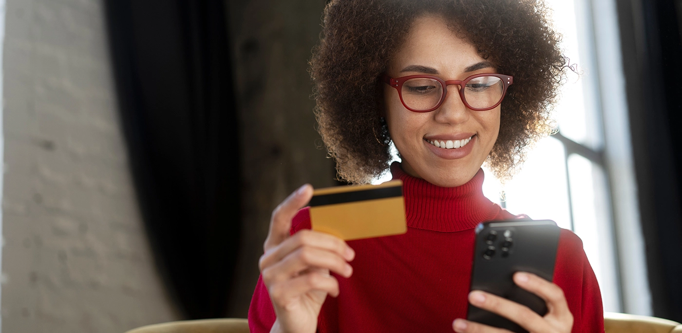 Black women with credit card in hand about to make a mobile purchase