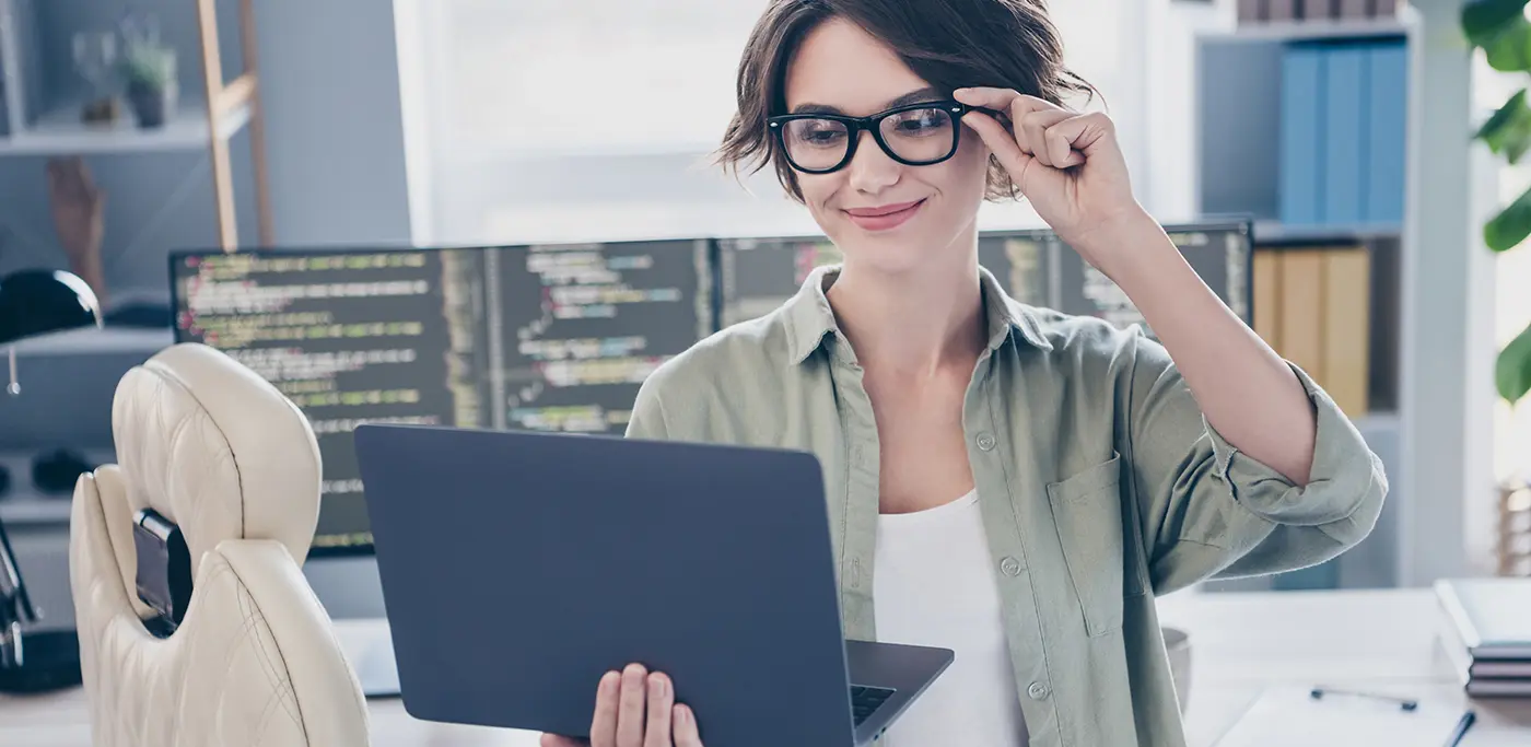 Female email coder stood in front of work desk