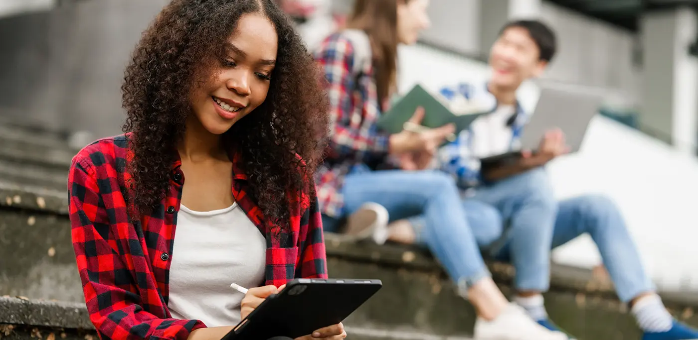 Students sat on stairs outside uni building