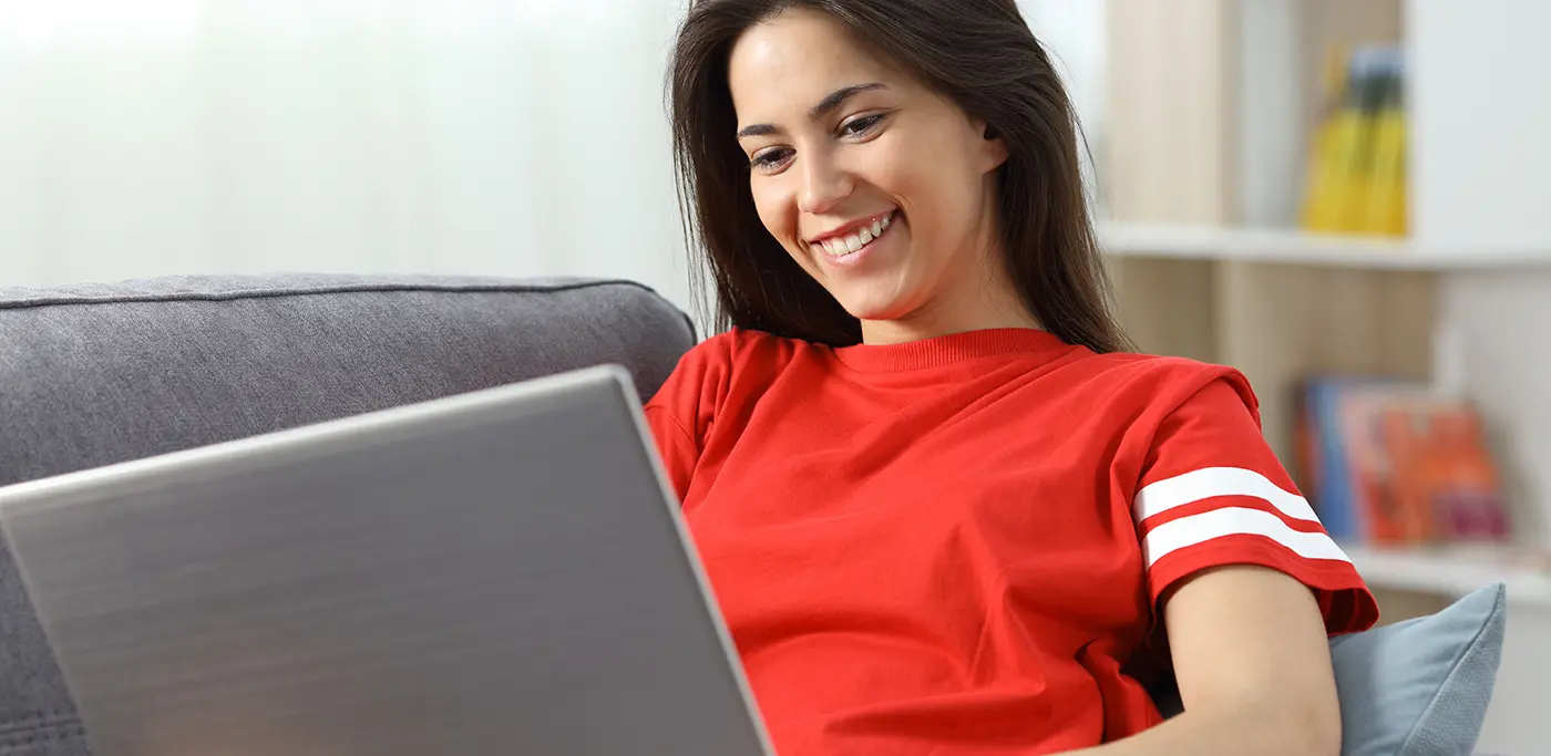 Women at home on laptop sitting on sofa