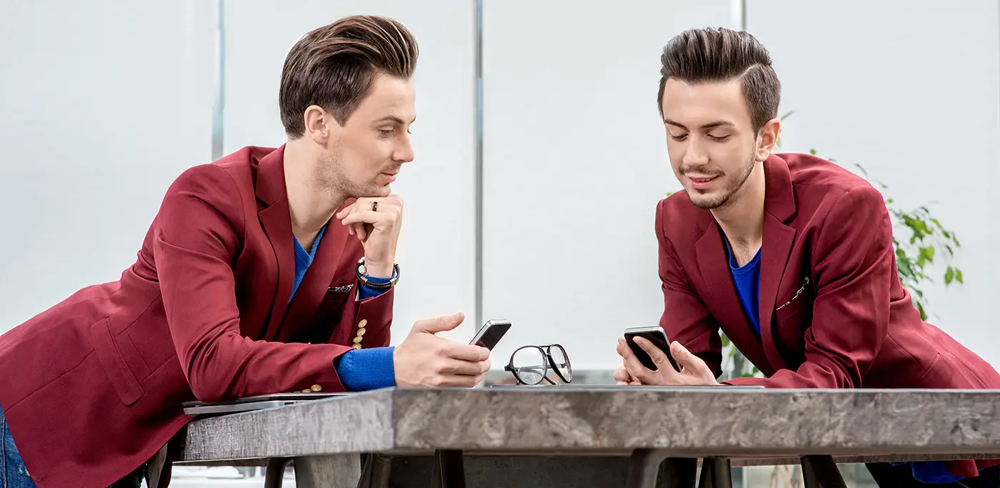 Male twins comparing mobile phones